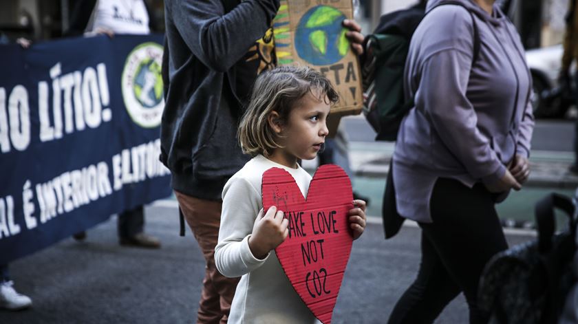 "Partilhem amor, não CO2", lê-se no cartaz que carrega Maya, na marcha pelo Clima, em Lisboa. Foto: Joana Gonçalves/ RR