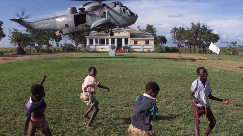 Crianças brincam na Beira perto de um helicóptero de ajuda humanitária. Foto: Reuters