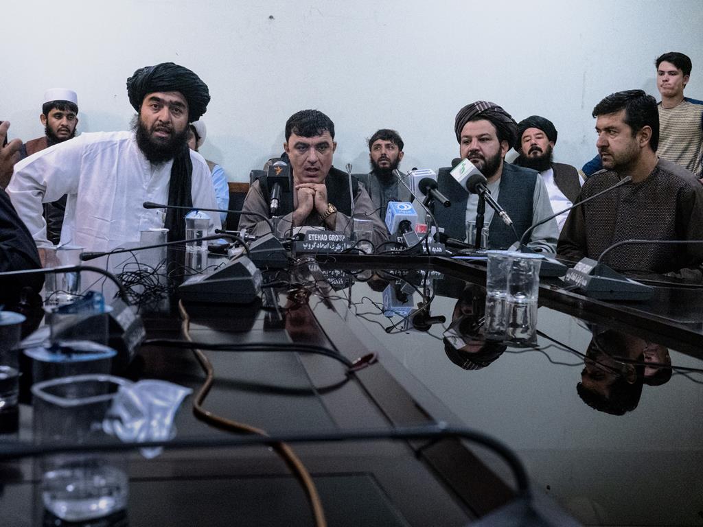 Mawlawi Assad Mutawakil (esquerda), chefe da Relação Cultural e Media dos talibãs e ex-governador de Kandahar, Rohullah Khanzada (centro), numa conferência de imprensa onde falaram sobre a entrega de Kandahar, bem como sobre o futuro da cidade sob domínio talibã.