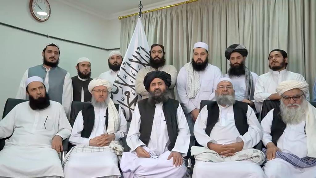 Mullah Baradar Akhund, alto funcionário dos Talibãs, sentado com um grupo de homens, faz uma declaração em vídeo, nesta imagem tirada de um vídeo gravado num local não identificado e divulgado a 16 de Agosto de 2021. Foto: Reuters