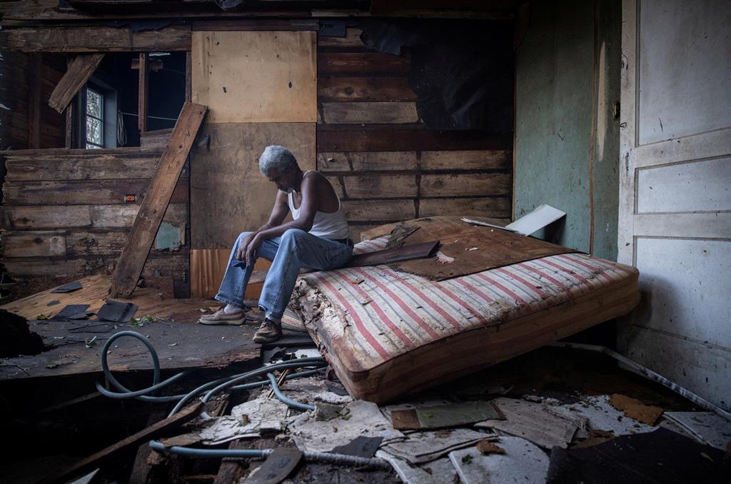 Theophilus Charles, de 70 anos, dentro da sua casa, totalmente destruída pelo furacão Houma, no Louisiana, EUA. Foto: Adrees Latif/Reuters