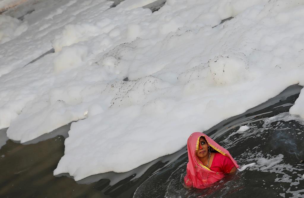 Uma mulher hindu no rio Yamuna, com sinais evidentes de uma poluição grave, durante um festival religioso em Nova Deli, na Índia. Foto: Adnan Abidi/Reuters