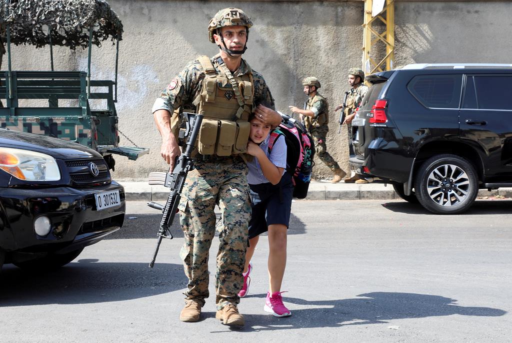 Um militar protege uma criança, durante um tiroteio em Beirute, no Líbano, em outubro. Foto: Mohamed Azakir/Reuters