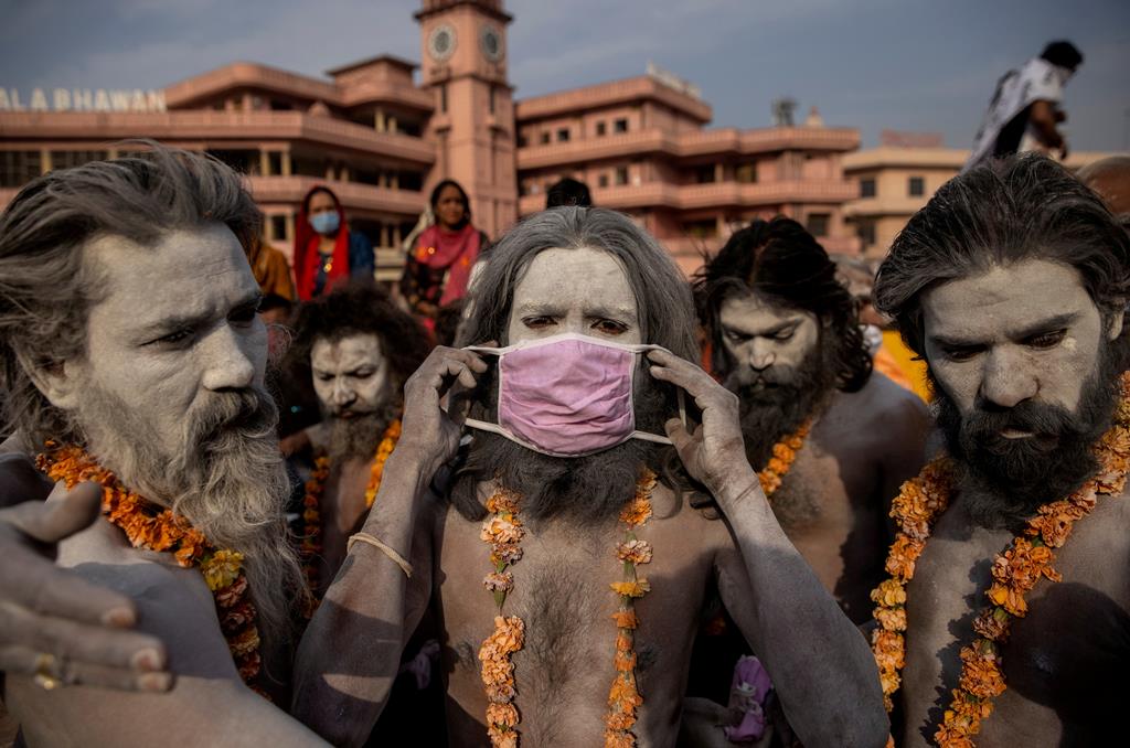 Naga Sadhu, líder religioso na comunidade hindu, retira a máscara antes de mergulhar no rio Ganges, em abril deste ano, durante o pico da pandemia de Covid-19. Foto: Danish Siddiqui/Reuters