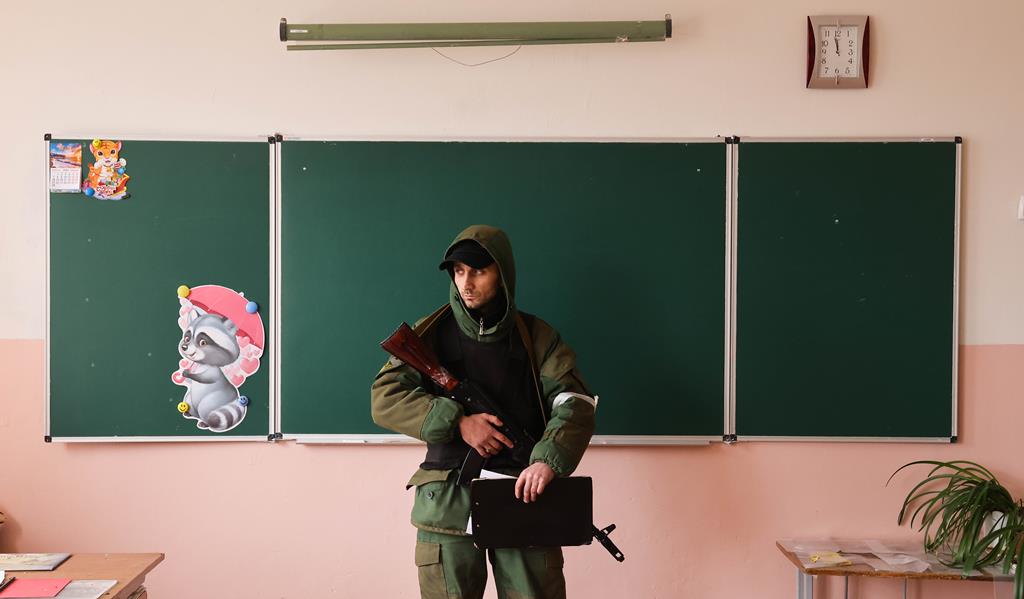 Um soldado numa sala de aula da Escola Secundária nº 50 na Rua Sokolovskogo danificada num ataque de bombardeamento. De acordo com dados preliminares, dois professores da escola foram mortos.. Foto: Alexander Ryumin/Reuters