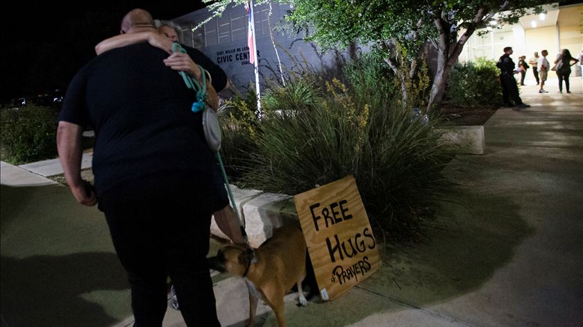 Mulher oferece conforto a familiares das vítimas à porta do centro cívico. Foto: Reuters