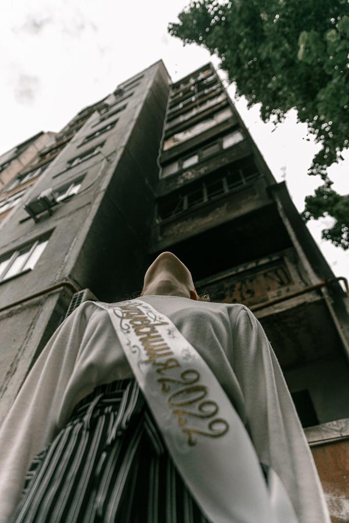 Estudante posa em frente a um prédio em ruínas para uma sessão fotográfica de graduação. Foto: @senykstas/Instagram via Reuters