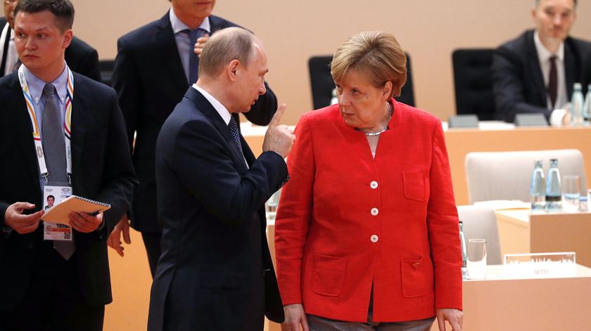 Putin e Merkel durante a sessão de abertura da cimeira. Foto: Philippe Wojazer/EPA