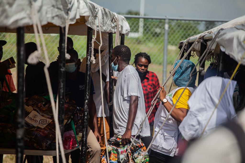 Haitianos deportados dos Estados Unidos são assistidos após a chegada ao Haiti. Foto: Richard Pierrin/EPA