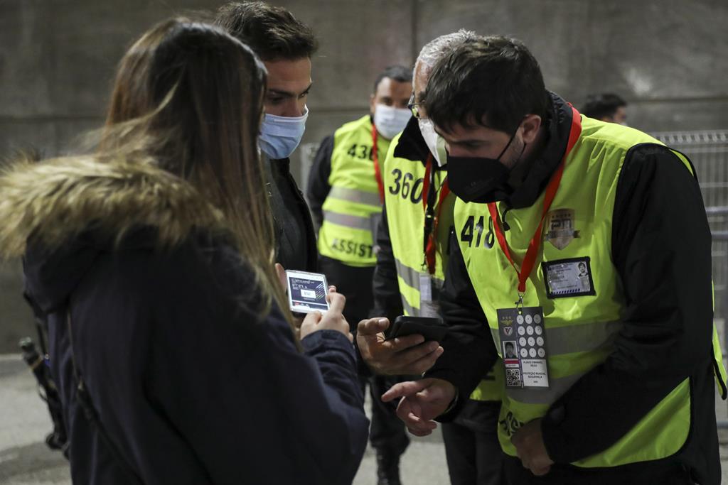 Adeptos mostram teste Covid-19 negativo para entrar num estádio. Foto: Miguel A. Lopes/EPA