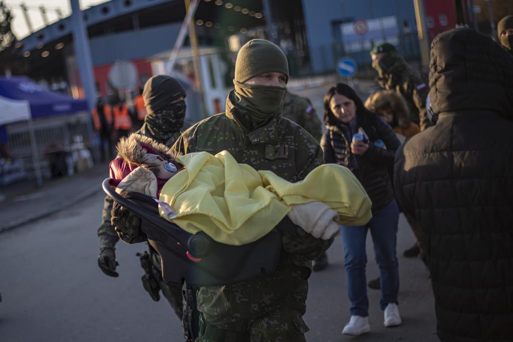 Ucrânia, refugiados, militar transporta criança. Foto: Martin Divisek/EPA