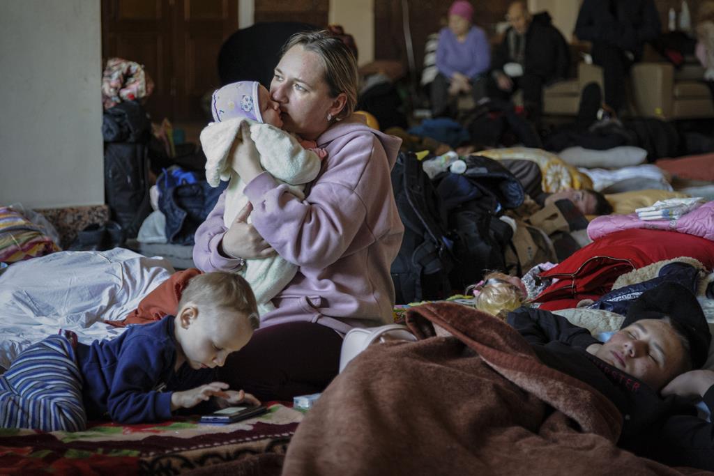 O futuro da Ucrânia ao colo. Uma mãe e as suas crianças aguardam por um comboio num abrigo em Lviv. Foto: Mykola Tys/EPA