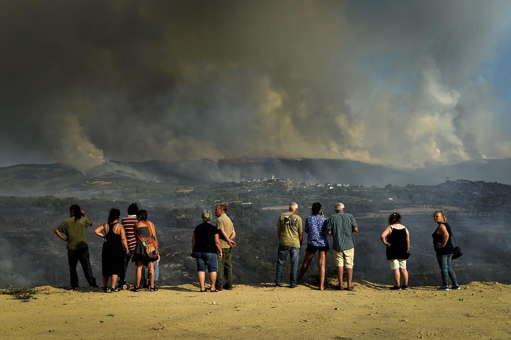 As chamas queimam uma encosta junto a casas de habitação durante um incêndio em Linhares da Beira, Celorico da Beira. Foto: Nuno André Ferreira/Lusa