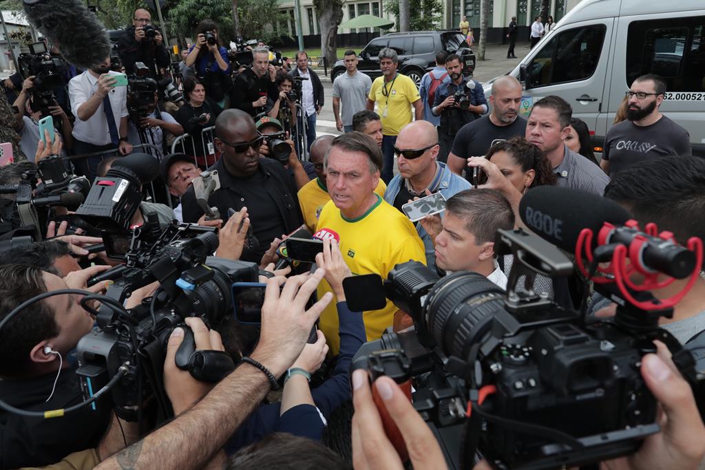 O Presidente foi votar com o que parecia ser um colete à prova de balas debaixo da t-shirt com as cores da bandeira do Brasil. Foto: André Coelho/EPA
