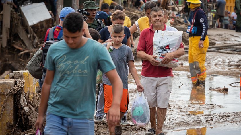 Pessoas transportam pertences depois de várias habitações serem destruídas pelas chuvas e deslizamentos em Tejerias, estado de Aragua, Venezuela, 09 de Outubro de 2022.  Foto: Rayner Pena R./EPA