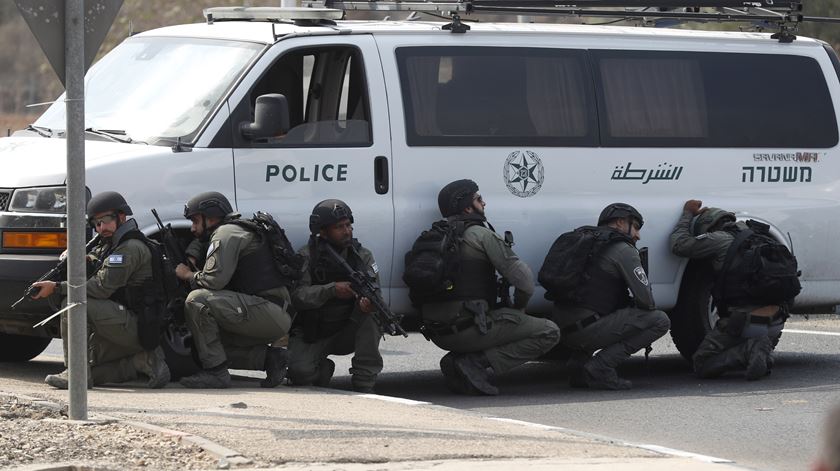 Soldados israelitas perseguem militantes numa estrada perto de Gaza. Foto: Atef Safadi/EPA