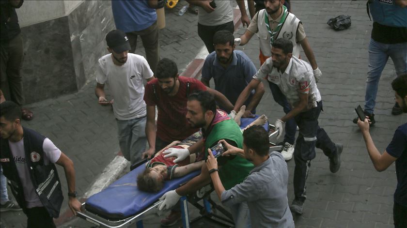 Uma criança é transportada, após ter sido ferida por um bombardeamento israelita na Faixa de Gaza. Foto: Haitham Imad/EPA