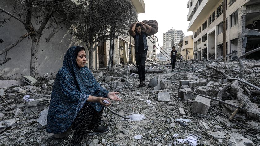 Mulher entre os escombros de ataque em Gaza. Foto: Mohammed Saber/EPA (Clique na seta para ver a fotogaleria)