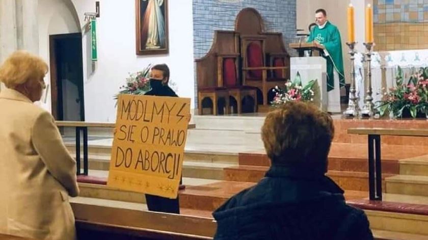 Manifestante contra as restrições ao aborto na Polónia com cartaz a dizer "rezemos pelo direito ao aborto". Foto: Facebook