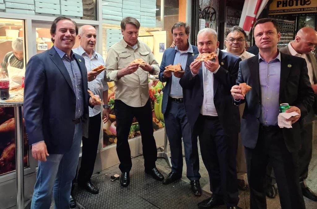 Jair Bolsonaro come pizza numa rua de Nova Iorque, acompanhado por Marcelo Queiroga e outros membros da comitiva. Foto: Twitter Luiz Ramos