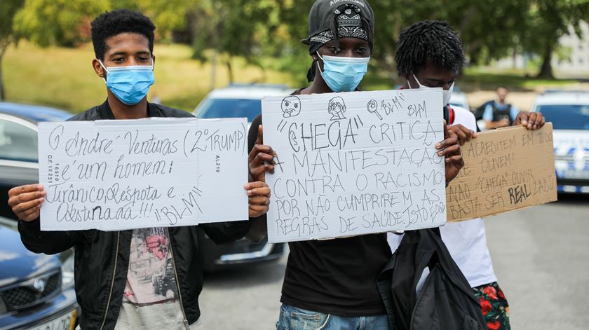 Jovens mostram cartazes de protesto contra a concentração promovida por André Ventura. Foto: Miguel A. Lopes/Lusa