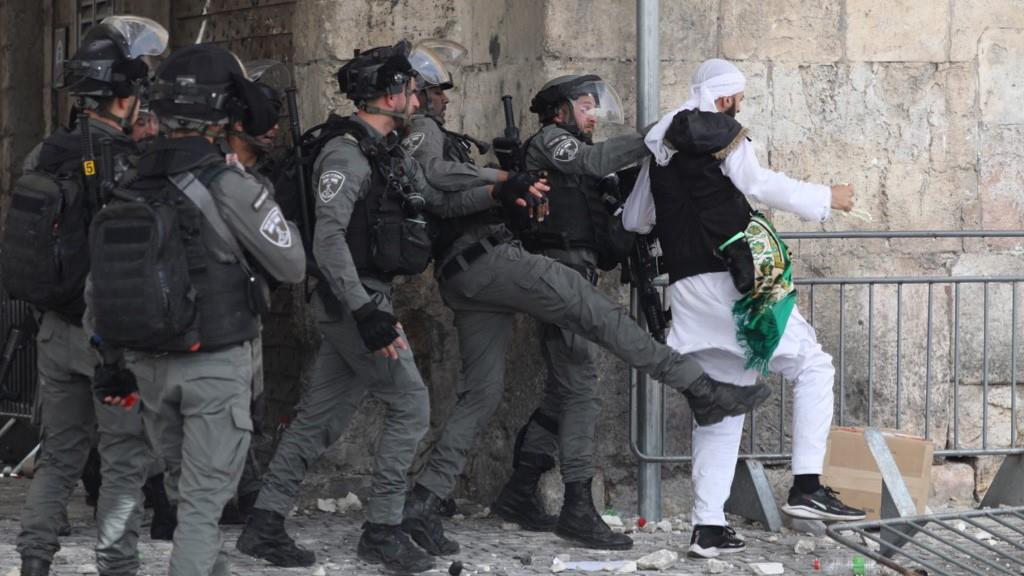 Polícia israelita empurra palestiniano durante confrontos. Foto: Abir Sultan/EPA