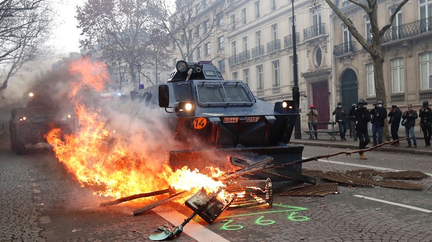 Veículo blindado da Gendarmerie, a Polícia Militar francesa, limpa barricada incendiada na rua, em Paris. Foto: Yoan Valat/EPA