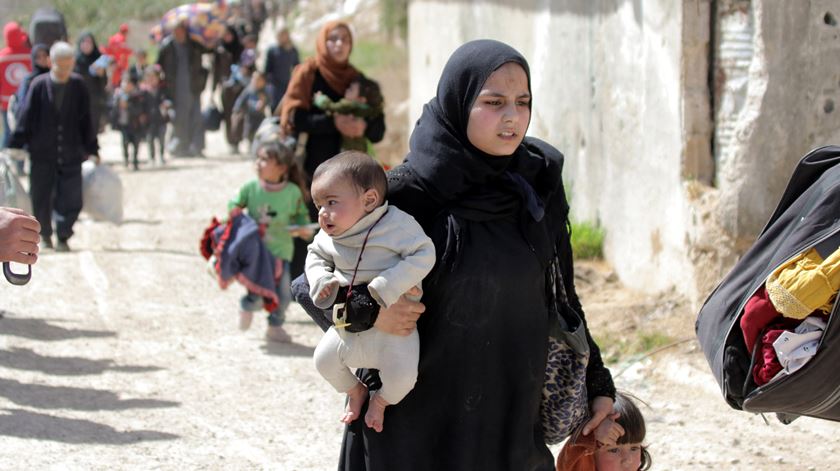 Civis deixam o Ghouta oriental, controlado pelos rebeldes, através do corredor seguro al-Wafideen, a 21 de Março. Foto: Foto: Youssed Badawi/EPA