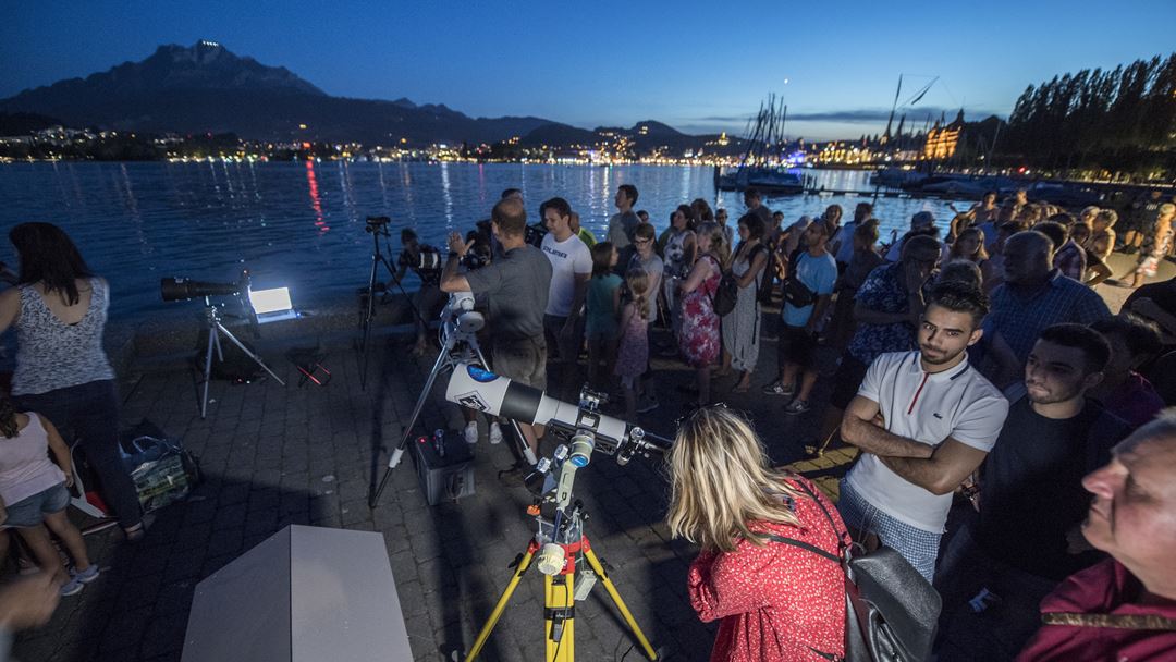 Pessoas preparam-se para testemunhar o eclipse lunar, no Lago Lucerna, Suíça. Foto: Urs Flueeler/EPA