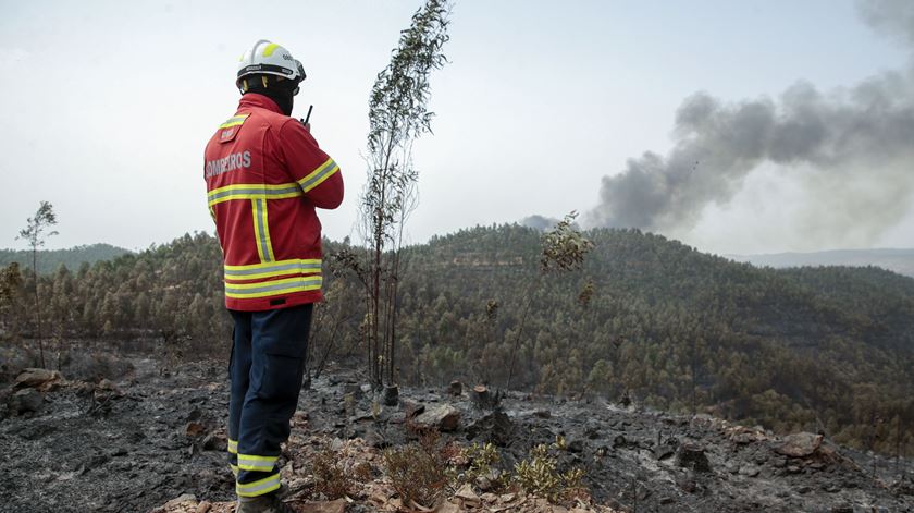 Um bombeiro observa um incêndio florestal na zona da Ribeira da Perna da Negra, na Serra de Monchique, no distrito de Faro, 4 de agosto de 2018. Foto: Filipe Farinha/Lusa