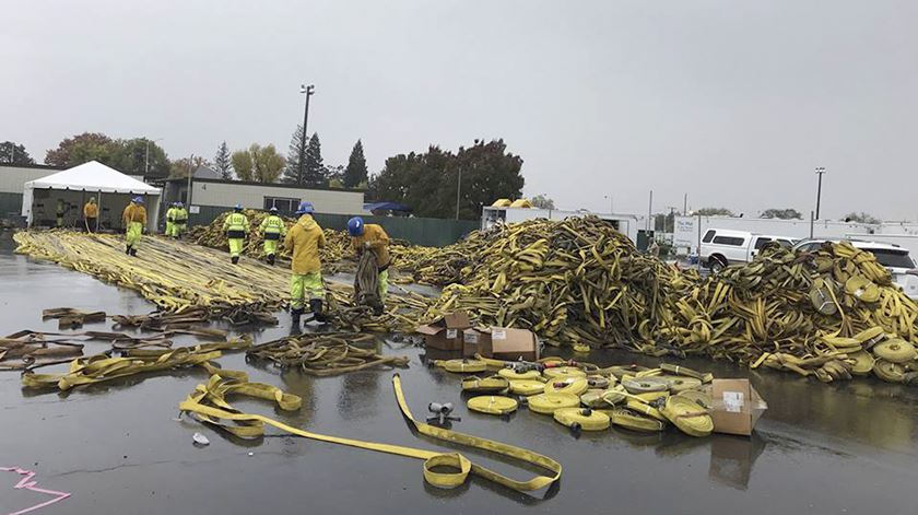 Bombeiros arrumam mangueiras depois de o incêndio ter sido dado como extinto, na Califórnia. Foto: EPA