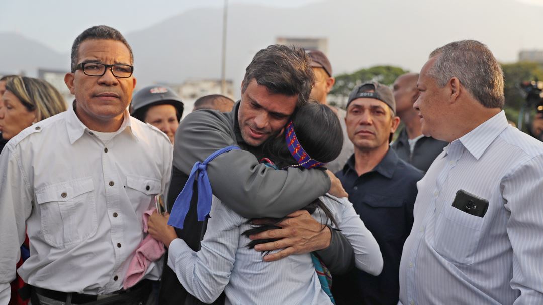 Leopoldo López abraça um apoiante depois de se juntar a Guaidó, nas ruas de Caracas. O líder da oposição foi libertado da prisão domiciliária por militares, no dia 30 de abril.  Fotografia: Rayner Pena/EPA