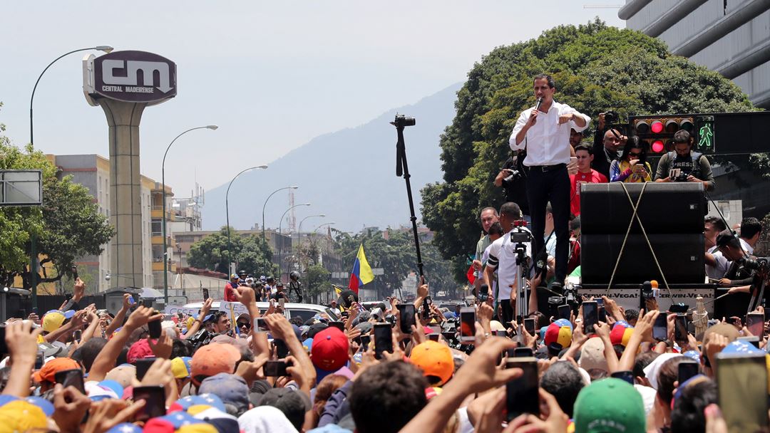 Juan Guaidó, líder da oposição, discursa perante a multidão que saiu à rua para o apoiar, no 1º de maio, um dia depois de começarem os confrontos na Venezuela. Guaidó chamou pelo segundo dia “toda a Venezuela para as ruas” para dar continuidade à Operação Liberdade. Fotografia: Miguel Gutierrez/EPA