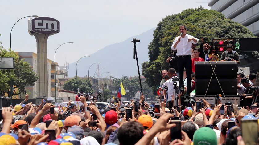 Juan Guaidó, líder da oposição, discursa perante a multidão que saiu à rua para o apoiar, no 1º de maio, um dia depois de começarem os confrontos na Venezuela. Guaidó chamou pelo segundo dia “toda a Venezuela para as ruas” para dar continuidade à Operação Liberdade. Fotografia: Miguel Gutierrez/EPA