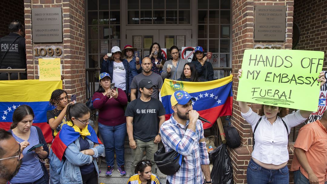 Manifestantes a favor e contra a mudança de regime na Venezuela reuniram-se no lado de fora da Embaixada da Venezuela, em Washington, no dia 1 de maio. Fotografia: Erik S. Lesser/EPA