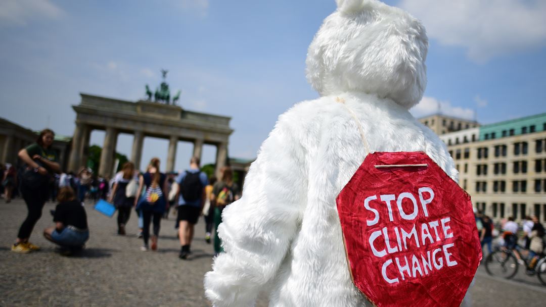 Um jovem vestido de urso polar no protesto junto às portas de Brandenburg, em Berlim, na Alemanha. Foto: Clemens Bilan/EPA