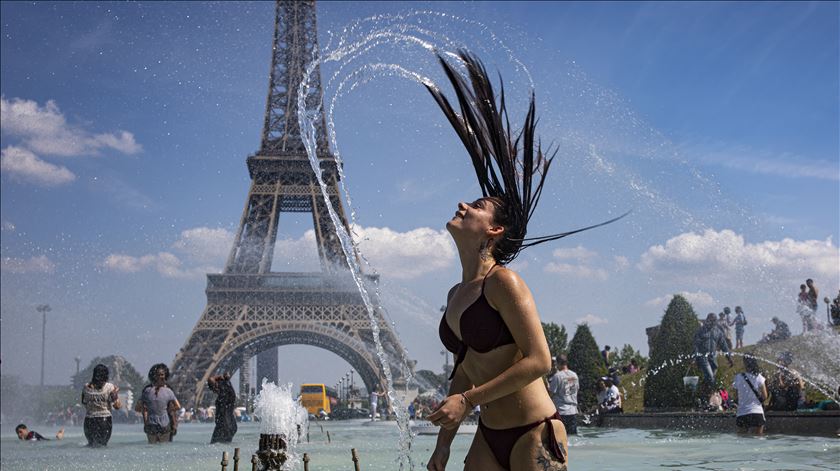 Parisienses refrescam-se junto à famosa Torre Eiffel. Foto: Ian Langsdon/EPA