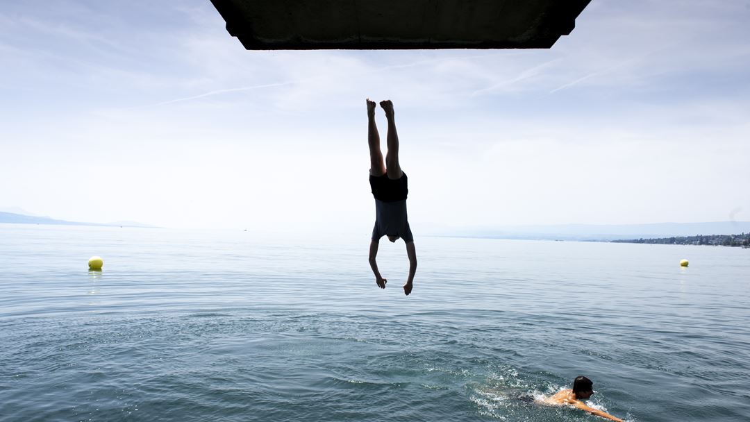 Jovem mergulha no lago Genebra. Foto: Sandra Hildebrandt/EPA