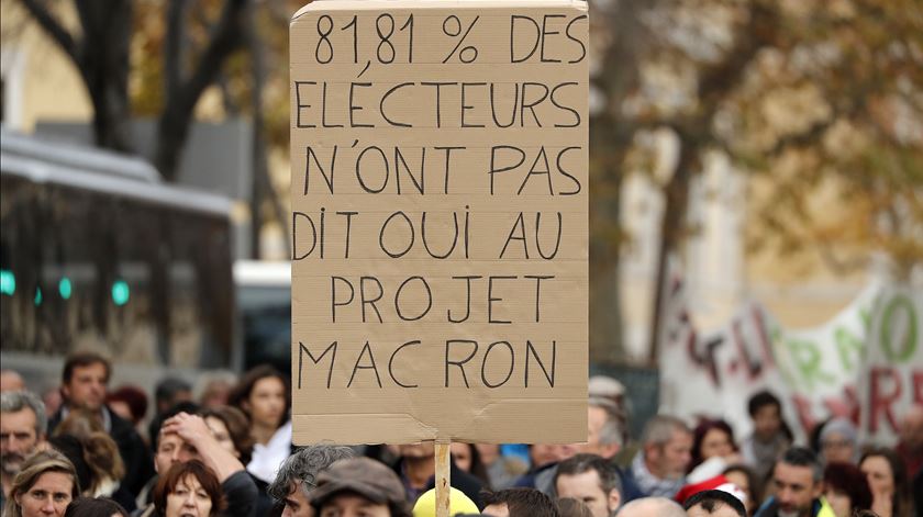 Manifestante com um cartaz, em que se lê: "81,86% dos eleitores não concordaram com o projeto de Macron", na greve nacional em França. Foto: EPA/Guillaume Horcajuelo
