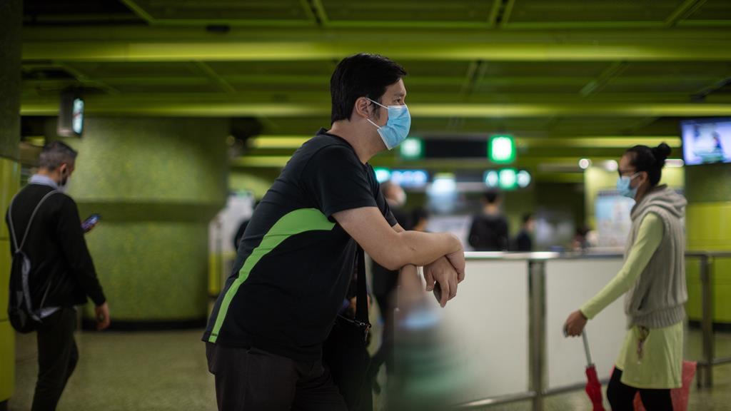 Homem com máscara, em Hong Kong. Foto: Jerome Favre/EPA