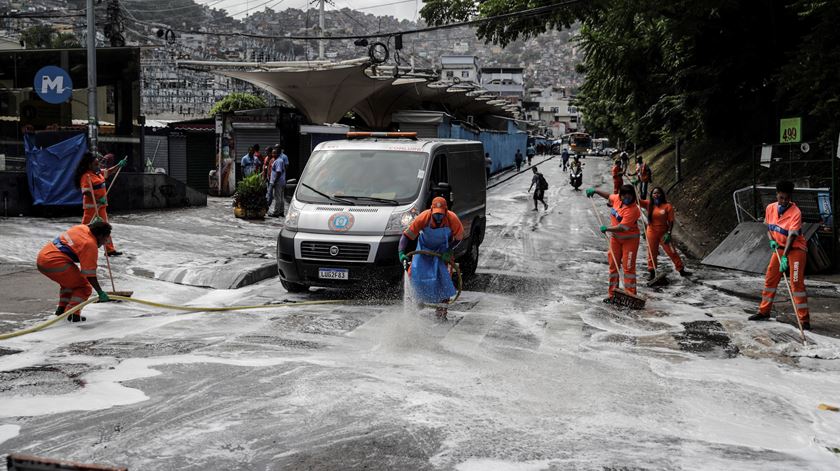 Funcionários limpam ruas na favela Rocinha, no Rio de Janeiro, onde vivem 69.161 pessoas. Foto: António Lacerda/ EPA