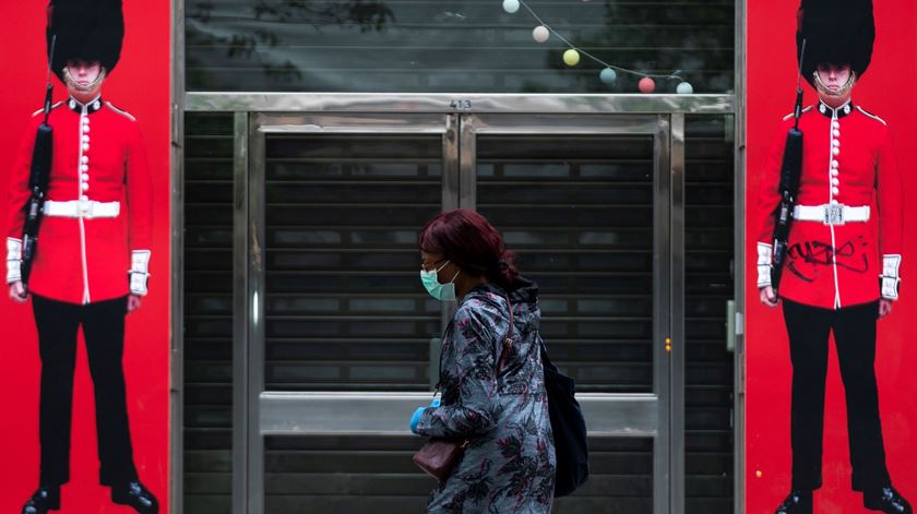 Uma mulher passa à frente de uma loja em Londres durante a pandemia. Foto: Will Oliver/EPA