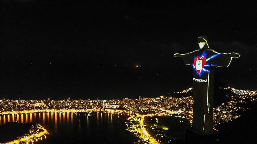 Estátua de Cristo Redentor, símbolo do Rio de Janeiro, com máscara para alertar a população para a ameaça da Covid-19. Foto: António Lacerda/EPA