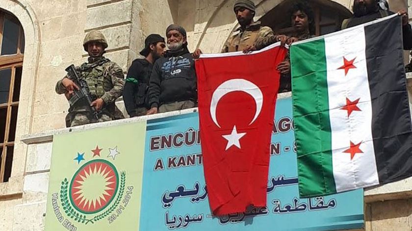 Membros do Exército Livre da Síria em Afrin, com uma bandeira da Turquia. Foto: EPA