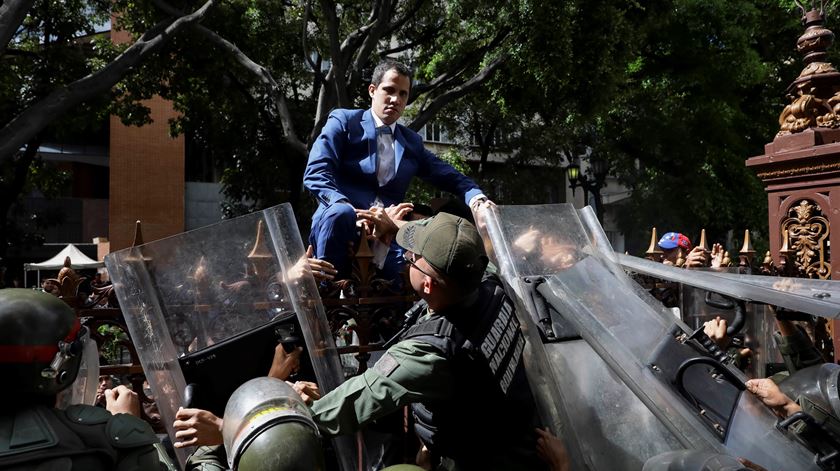 Juan Guaidó tenta entrar na Assembleia Nacional, em Caracas, na Venezuela, este domingo. O edifício estava guardado pela polícia, para impedir a sua entrada e de deputados da oposição, por alegadamente não estarem “legalmente habilitados”. Foto: EPA/Rayner Pena