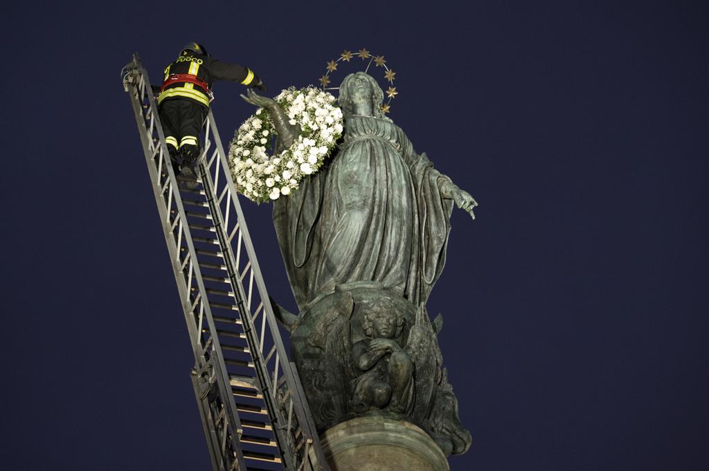 Estátua da Virgem Maria, em Roma, foi decorada com flores. Foto: Claudio Peri/EPA