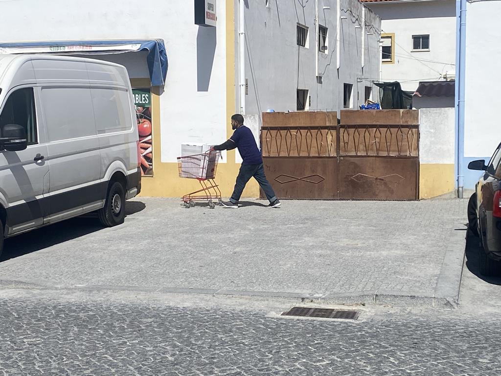 Imigrante a repôr produtos nas lojas de imigrantes de Vila Nova de Milfontes. João Cunha/RR
