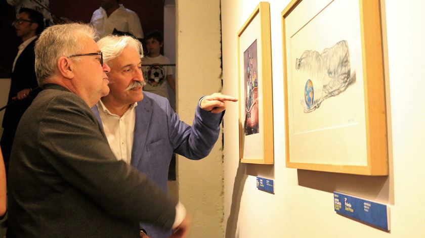 O diretor do Museu Nacional de Imprensa, Luiz Humberto Marcos, mostra ao ministro da cultura a caricatura vencedora do grande prémio do XX PortoCartoon.