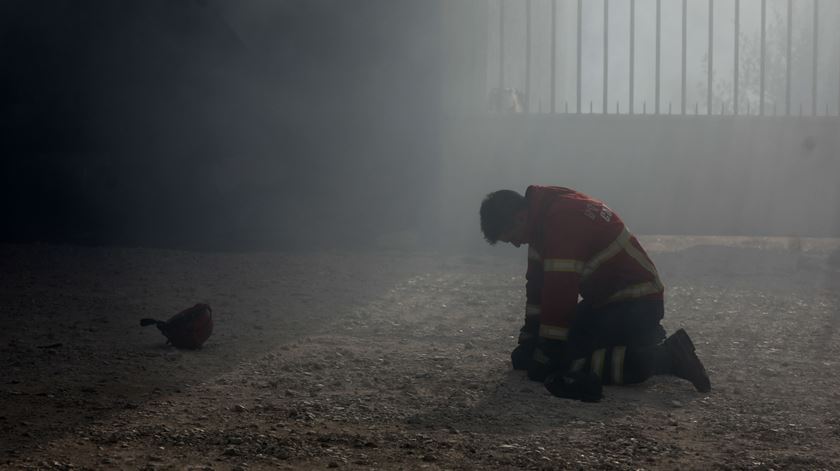 Um bombeiro em dificuldades este domingo no combate ao incêndio que começou na Lousã, em Vila Nova de Poiares. Foto: Paulo Novais/Lusa