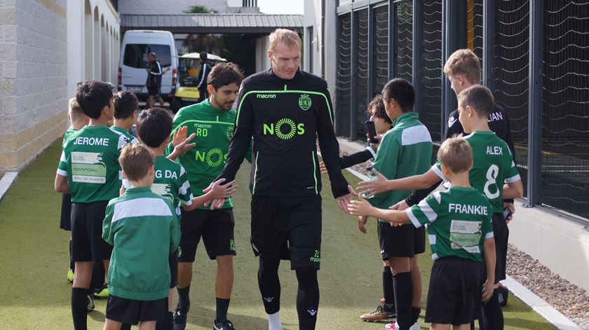 Mathieu acarinhado por crianças antes de regressar aos treinos em Alcochete. Foto: Sporting